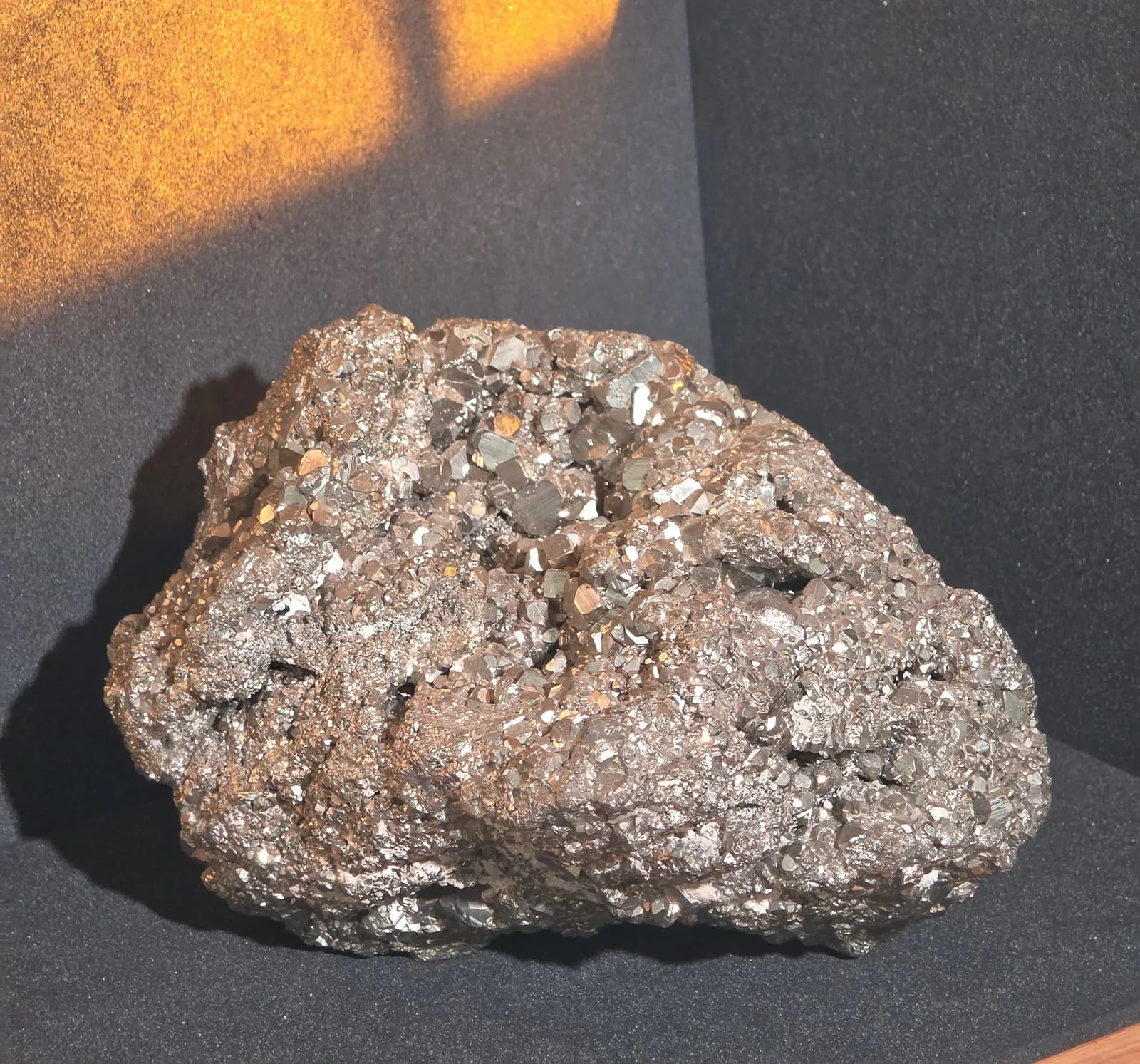 A large raw pyrite cluster catching warm light